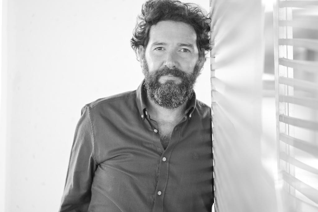 Retrato en blanco y negro de Ramón Maqueda apoyado en una pared